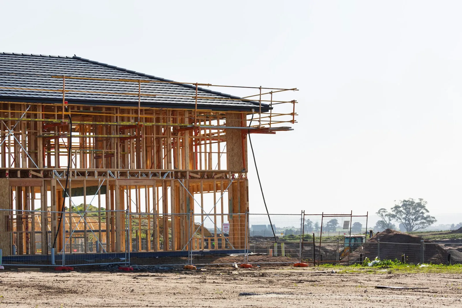 Rangka rumah dua lantai dalam tahap konstruksi dengan struktur kayu dan atap genteng